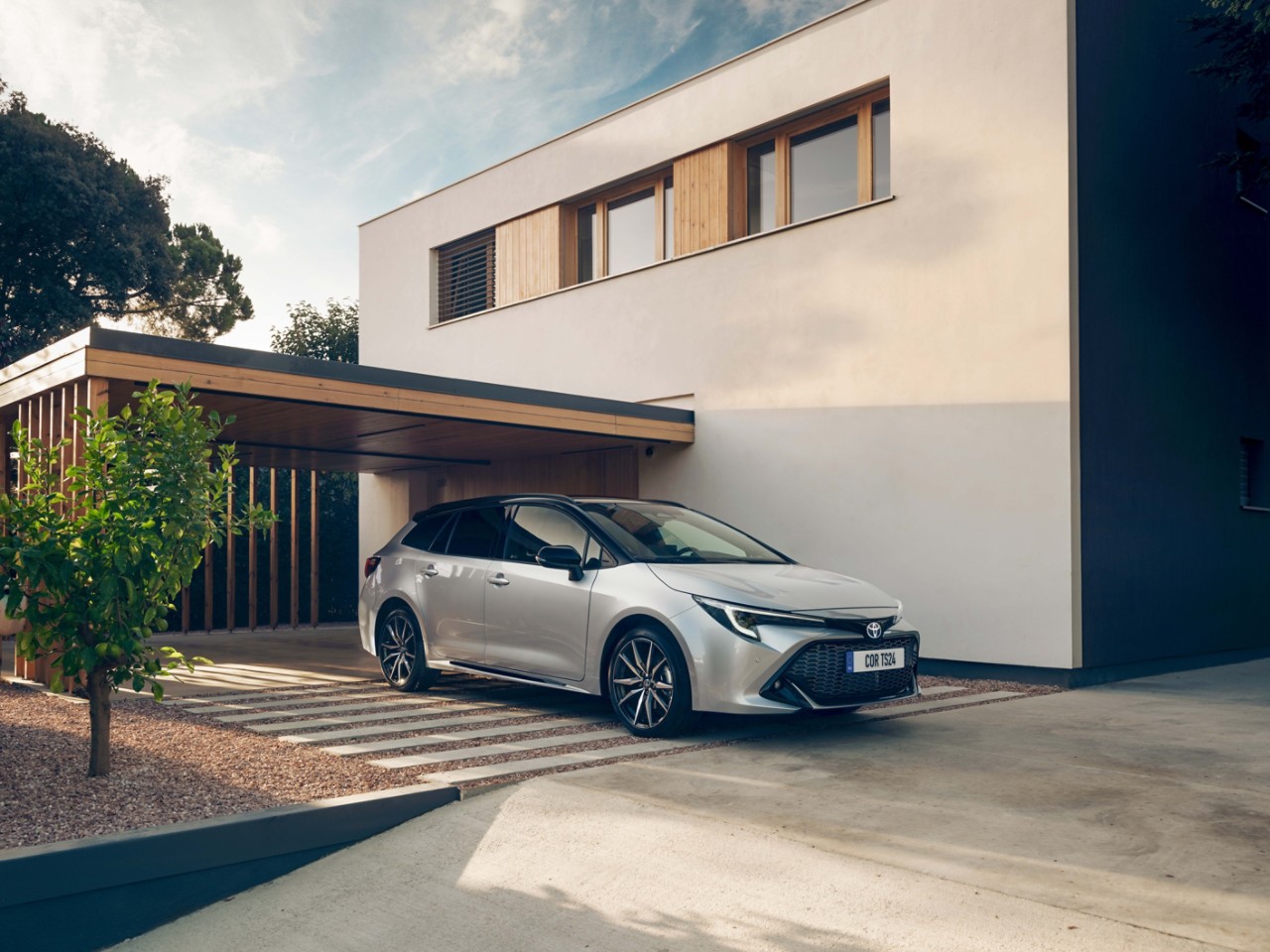 Toyota Corolla Touring Sports parkt vor einem modernen Haus